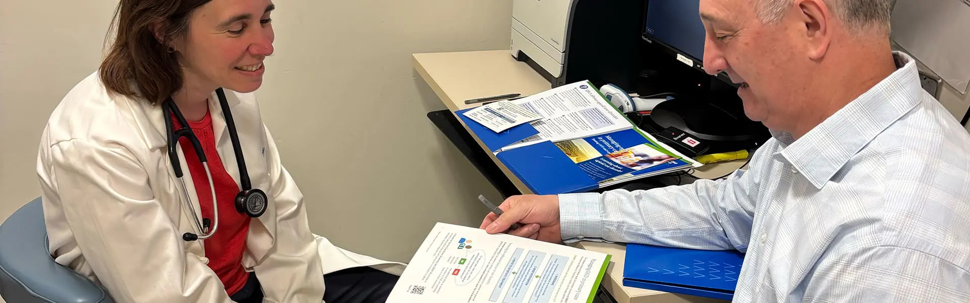 Photo of academic detailer sharing information with clinician in office